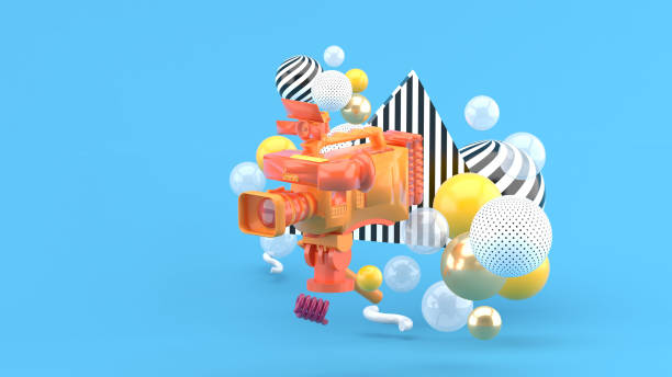 istock An orange video camera surrounded by colorful balls on a blue background.-3d render. 1340887599