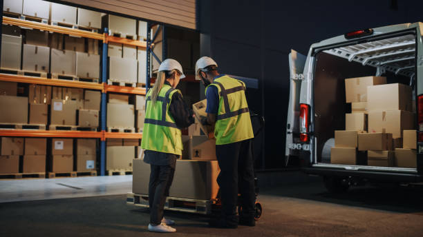 istock Outside of Logistics Retailer Warehouse With Female Manager Using Tablet Computer, Worker Loading Delivery Truck with Cardboard Boxes. Online Orders, Purchases, E-Commerce Goods, Supply. 1340887627