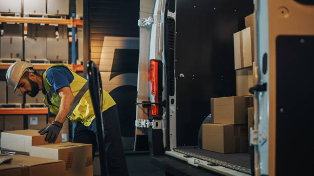 Handsome Latin Male Worker Loads Cardboard Boxes into Delivery Truck. Delivering Online Orders, E-Commerce Goods, Food, Medicine Supply. Tired Frontline Hero Doing Job. Handsome Latin Male Worker Loads Cardboard Boxes into Delivery Truck. Delivering Online Orders, E-Commerce Goods, Food, Medicine Supply. Tired Frontline Hero Doing Job. logistical stock pictures, royalty-free photos & images