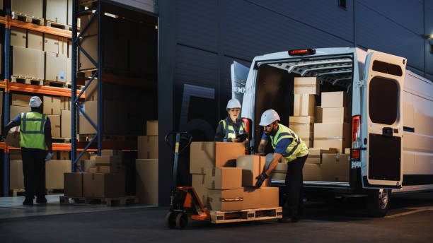 outside of logistics retail warehouse with inventory manager using tablet computer, talking to worker loading delivery truck with cardboard boxes, online orders, food and medicine supply, e-commerce - vrachtcontainer stockfoto's en -beelden