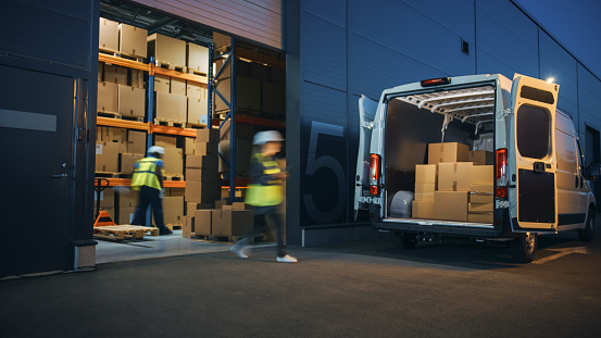 Outside of Logistics Distributions Warehouse Diverse Team of Workers Loading Delivery Truck with Cardboard Boxes. Online Orders, Purchases, E-Commerce Goods, Supply Chain. Blur Motion Shot.