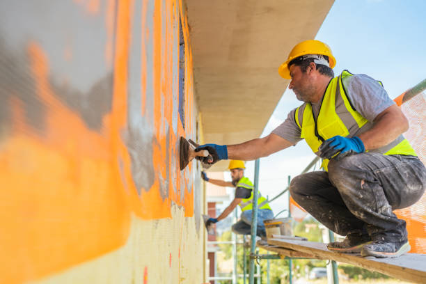 operai edili che applicano intonaco sulla facciata dell'edificio - plaster plasterer wall repairing foto e immagini stock