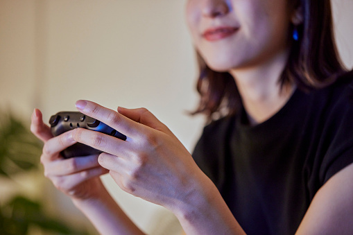 Young Japanese woman playing games in the living room