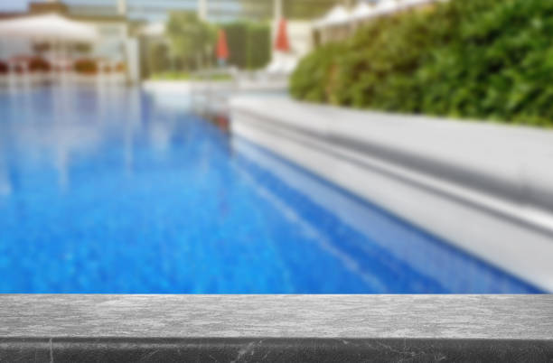 istock Grey stone deck near swimming pool outdoors on sunny day. Space for text 1340892692