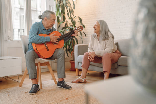 istock Man playing guitar at home 1340893100