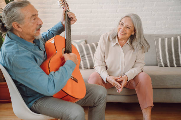 istock Man playing guitar at home 1340893108