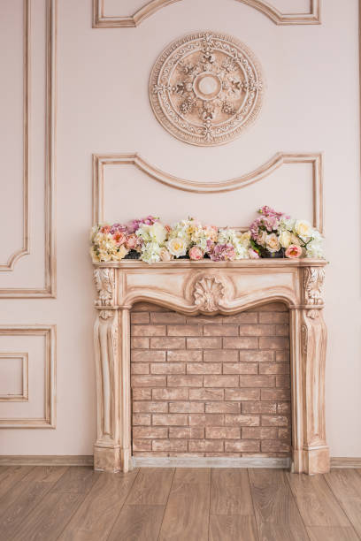 istock Beautiful beige fireplace with decorative flowers close-up 1340894471
