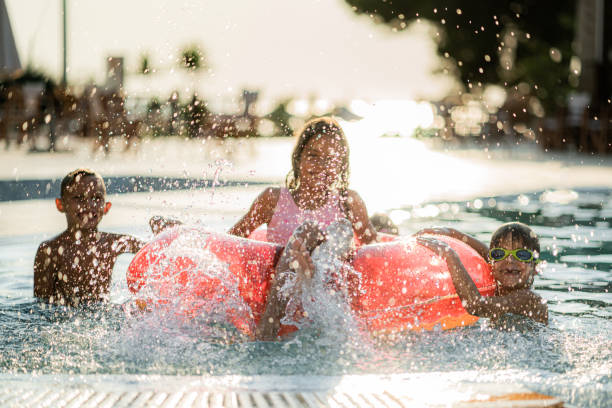 istock Cheerful kids having fun during summer day in the swimming pool 1340894542
