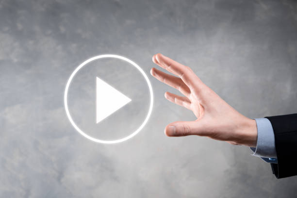 istock Businessman pressing, hold play button sign to start or initiate projects.Video Play Presentation. Idea for business, technology.media player button. Play icon.Go. 1340898929
