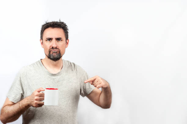 istock Dark-haired man in gray shirt with expression of wanting coffee or tea 1340899701