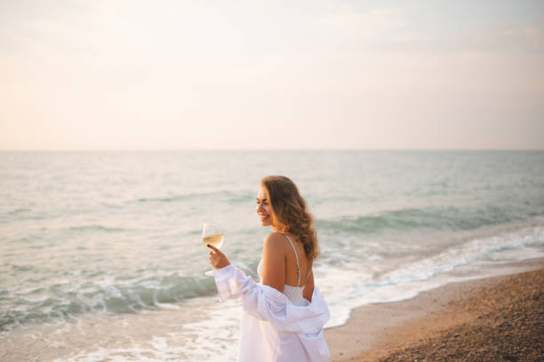 istock Young woman rest at sea shore with wine 1340901519