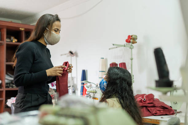istock Constructive businesswoman creating her designs while her client watches as she designs on the fabric 1340911328