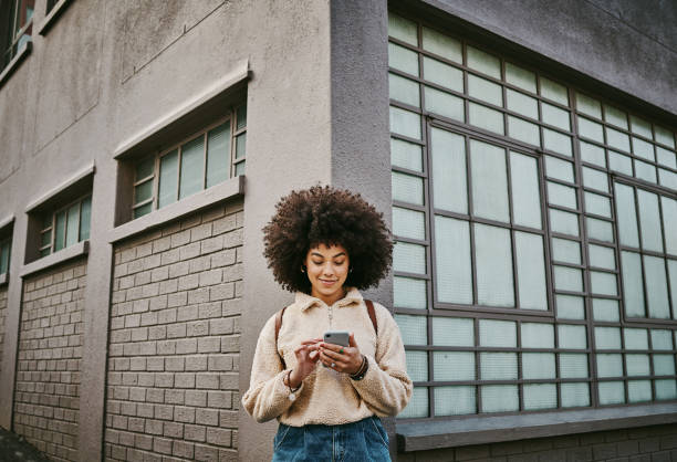 Shot of a beautiful young woman using her cellphone while out in the city stock photo