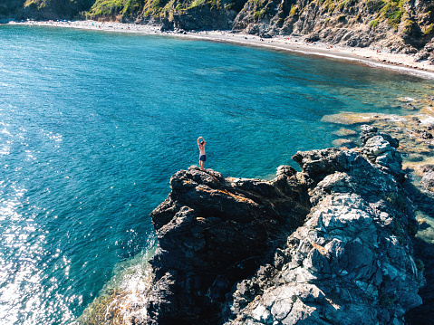 Aerial view of a man standing on a rock in the sea. Elba Island, Tuscany, Italy.