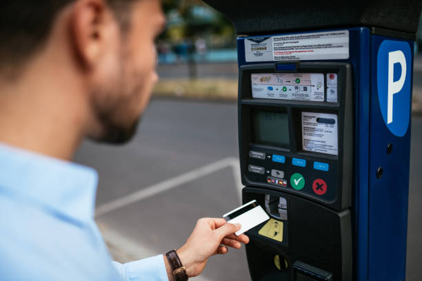 Business person paying parking in the city Millennial businessman in full suit or businesswear in Berlin, Germany parking meter stock pictures, royalty-free photos & images