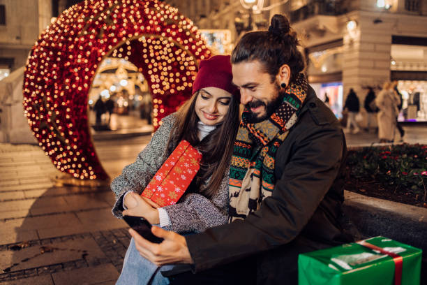 istock Happy couple using smartphone and enjoying after Christmas shopping 1340921203