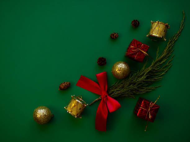 istock Christmas composition. Spruce branches, gift boxes, red bows, Christmas balls, sweets, decorations on a green background. Christmas, winter, new year concept. 1340924206