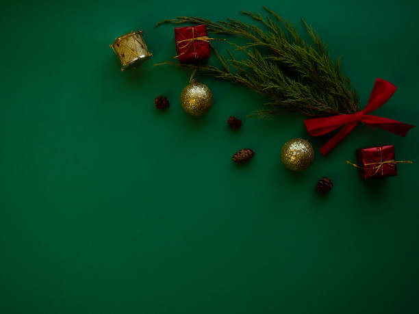 istock Christmas composition. Spruce branches, gift boxes, red bows, Christmas balls, sweets, decorations on a green background. Christmas, winter, new year concept. 1340924212