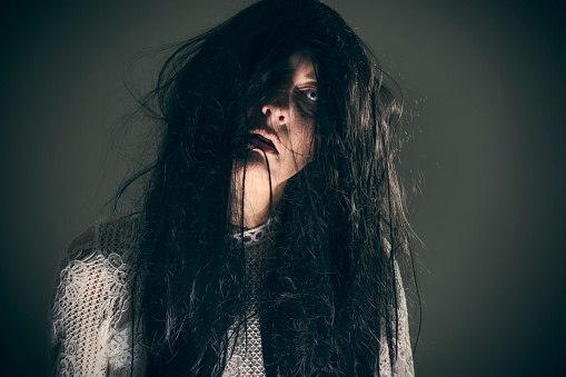 Mujer espeluznante con el pelo desordenado photo