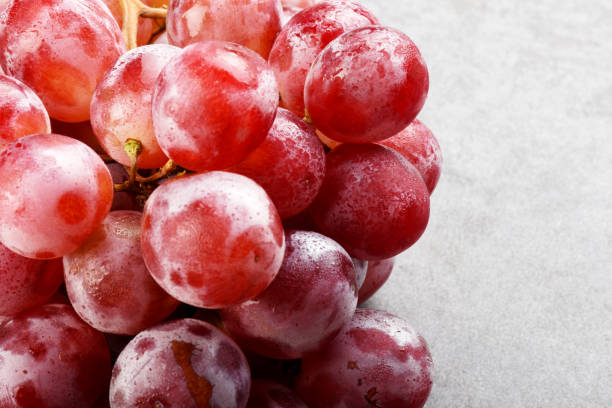 Red grapes on the gray color stone texture with copy space Bunch of red grapes on the gray color stone texture with copy space frozen grapes stock pictures, royalty-free photos & images