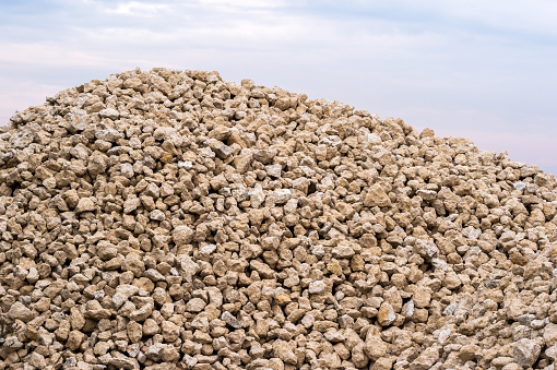 A large pile of sand-colored rubble against a gray-blue sky. Background.