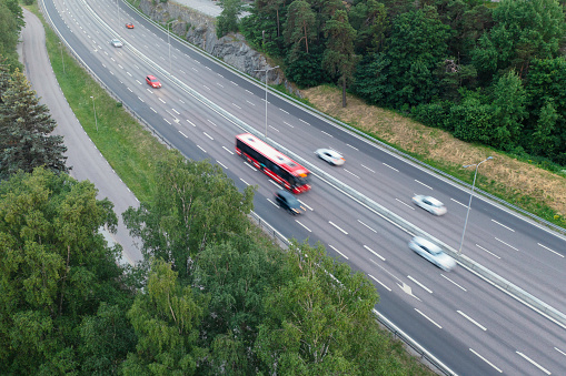 Aerial view of a bus and cars in motion on the E18 highway outside Stockholm.