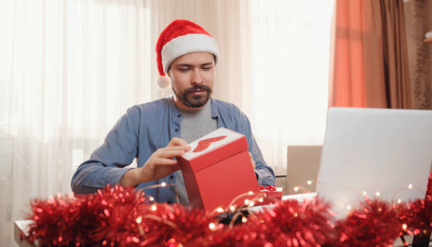 istock hipster man with red cup sitting home at Christmas time. 1340929106