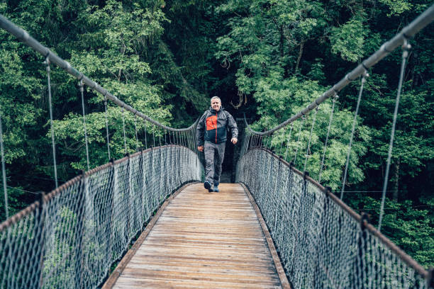 istock Man hikes along suspension bridge in the rain 1340931194