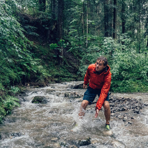 istock Young man hikes through freshwater stream 1340931881