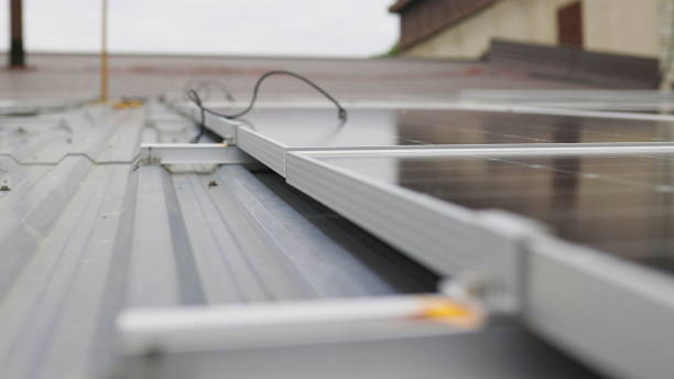istock Close up of mounting solar panel, installing solar panels on house. Fixing and connection of modern solar panels. Rows of sustainable energy solar panels installed on terrace. Solar panels at home 1340934980