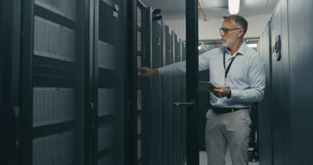istock Shot of a mature man using a digital tablet while working in a data centre 1340936089