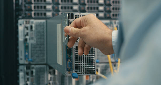 снимок человека, осматривающего жесткий диск в центре обработки данных - network server data center installing стоковые фото и изображения