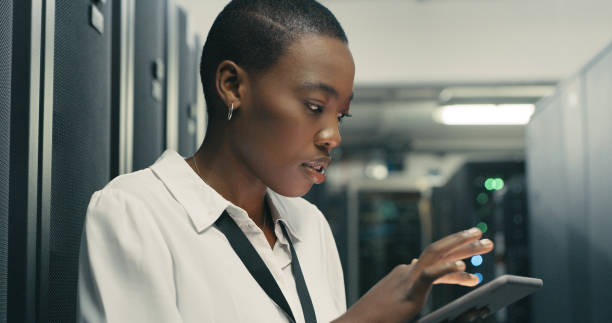 istock Shot of a young woman using a digital tablet while working in a data centre 1340936115