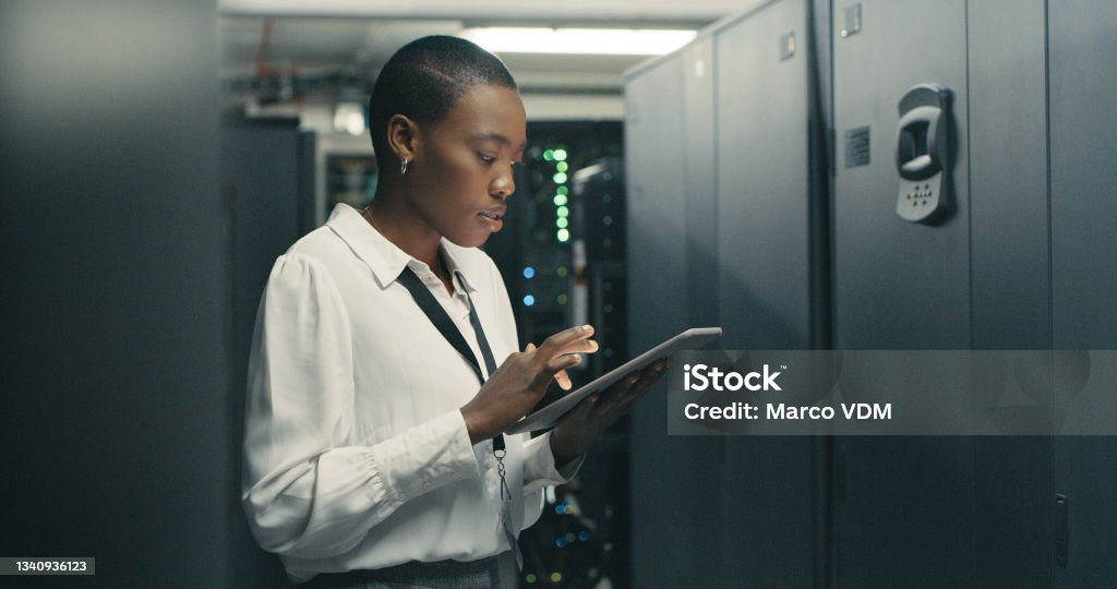 Shot of a young woman using a digital tablet while working in a data centre The smartest tech whiz in the bizz Security Stock Photo
