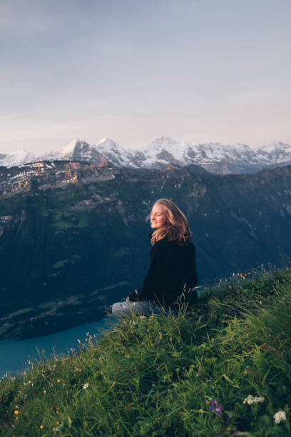 istock Female hiker relaxes on mountain ridge at sunrise 1340941796