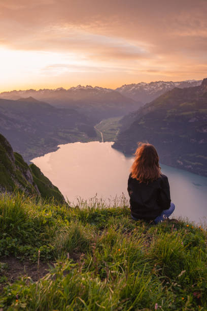 istock Female hiker relaxes on mountain ridge at sunrise 1340941797