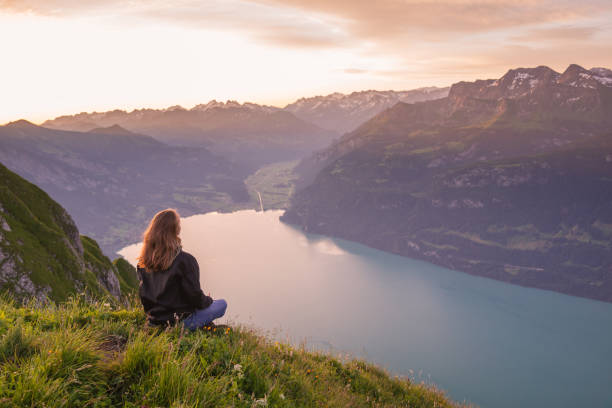 istock Female hiker relaxes on mountain ridge at sunrise 1340941856