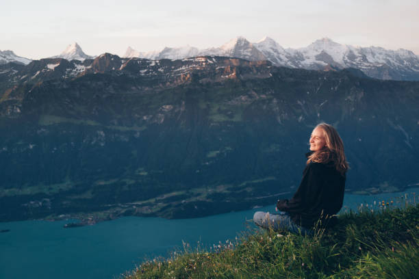 istock Female hiker relaxes on mountain ridge at sunrise 1340941922