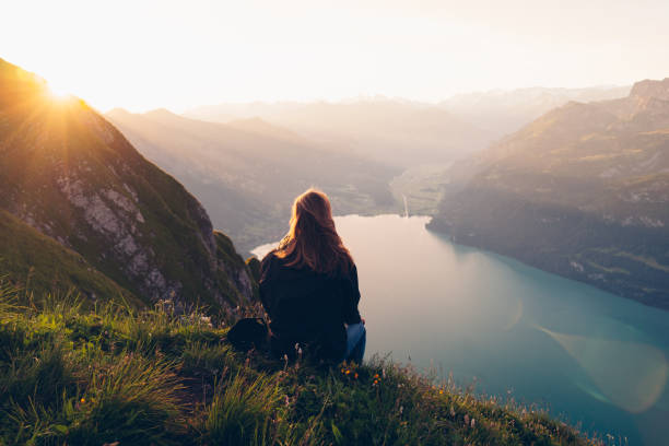 istock Female hiker relaxes on mountain ridge at sunrise 1340942458