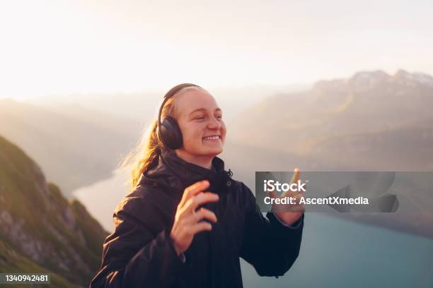 Female Hiker Listens To Music At Sunrise Stock Photo - Download Image Now - Listening, Wireless Headphones, Headphones