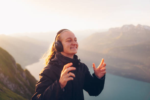 туристка слушает музыку на рассвете - mountain range audio стоковые фото и изображения