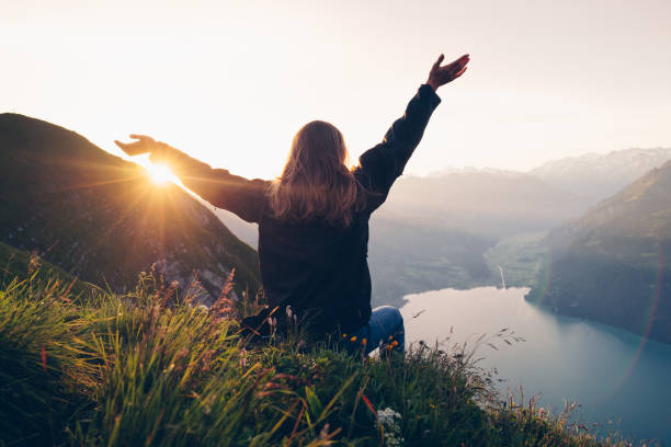 istock Female hiker relaxes on mountain ridge at sunrise 1340942505