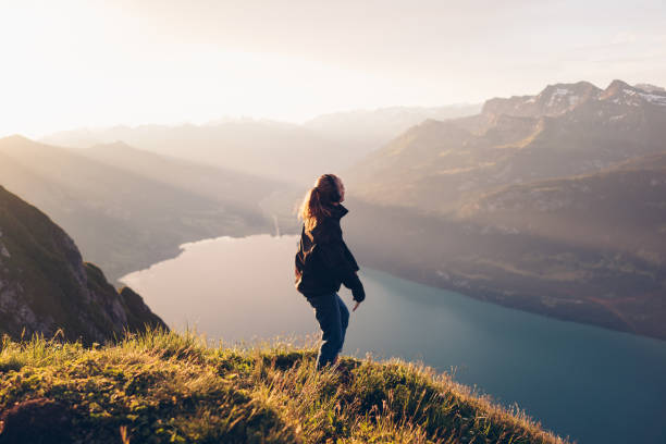 istock Female hiker relaxes on mountain ridge at sunrise 1340942550