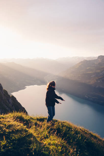 istock Female hiker relaxes on mountain ridge at sunrise 1340942572