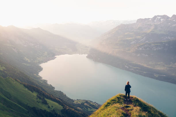istock Female hiker relaxes on mountain ridge at sunrise 1340942604