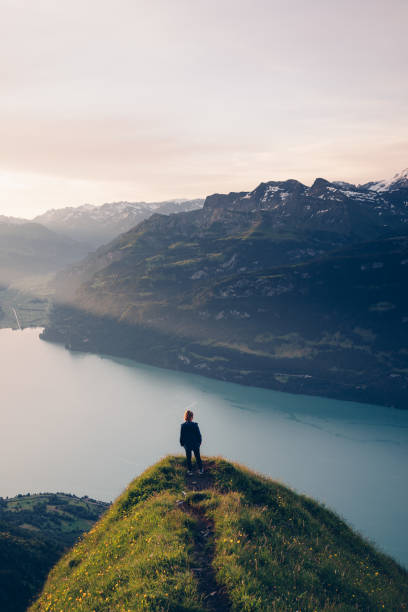 istock Female hiker relaxes on mountain ridge at sunrise 1340942617