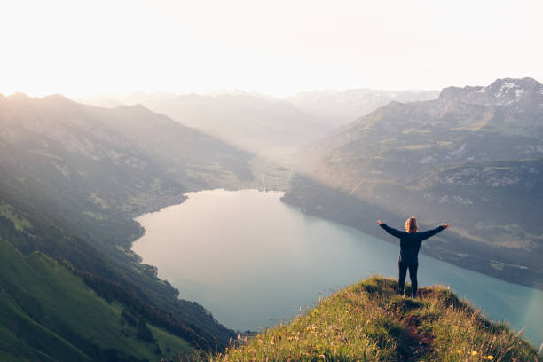 istock Female hiker relaxes on mountain ridge at sunrise 1340942642