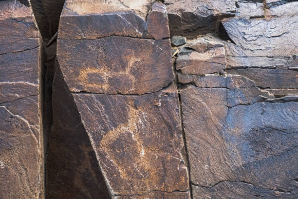 istock Ancient cave paintings on rocks. Bronze Age, Iron Age and Middle Age rock art. Tanbaly tas petroglyphs in Kazakhstan. 1340942645