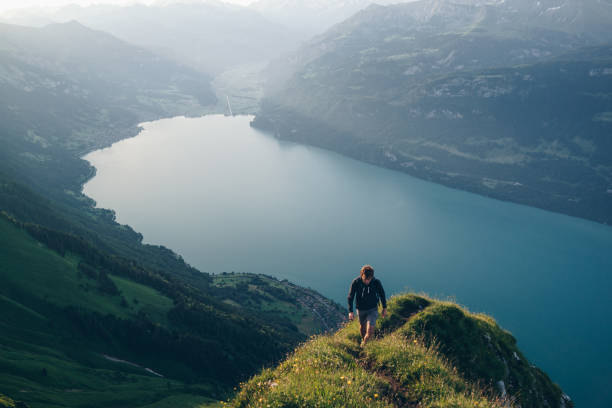 istock Young man hikes up mountain ridge, at sunrise 1340942687