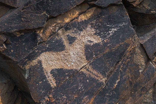 istock Ancient cave paintings on rocks. Bronze Age, Iron Age and Middle Age rock art. Tanbaly tas petroglyphs in Kazakhstan. 1340942704